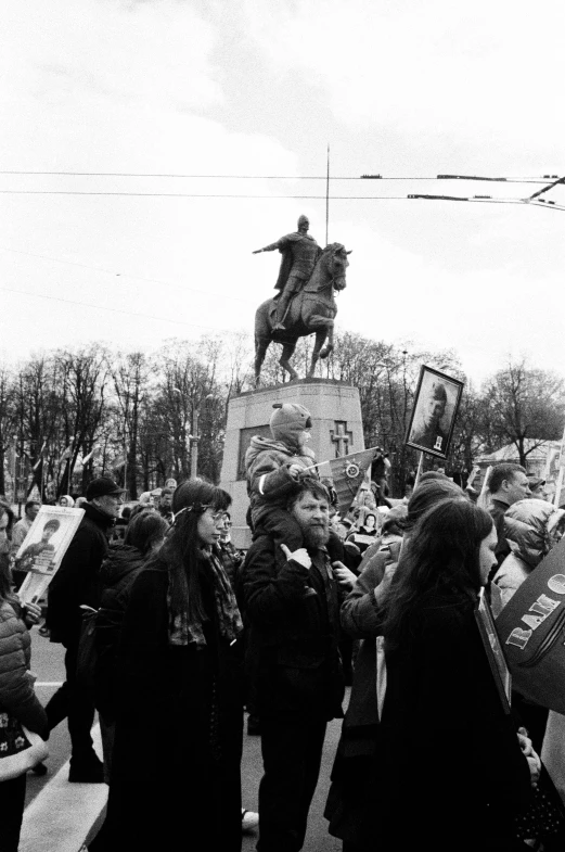 black and white pograph of some people and statue