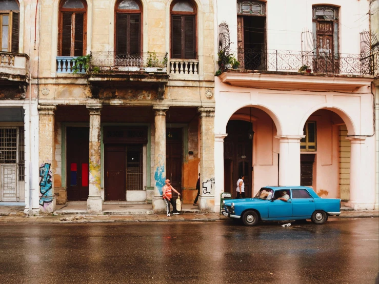 a car in front of some old, run down houses