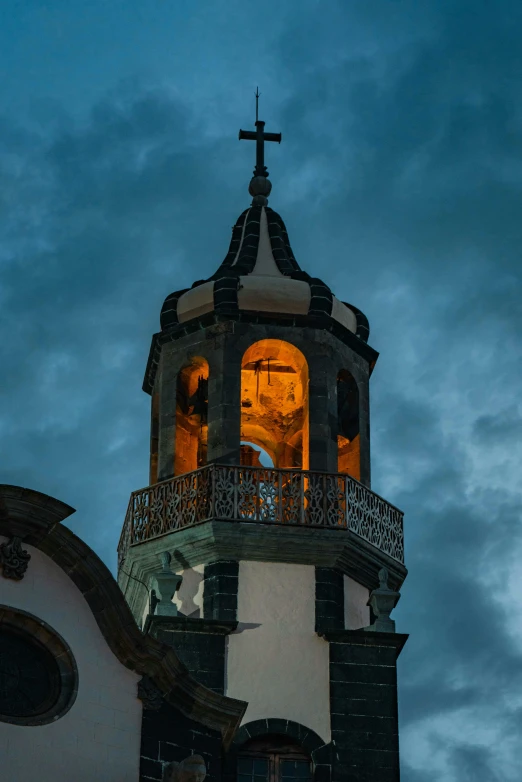 a clock tower with a cross at the top