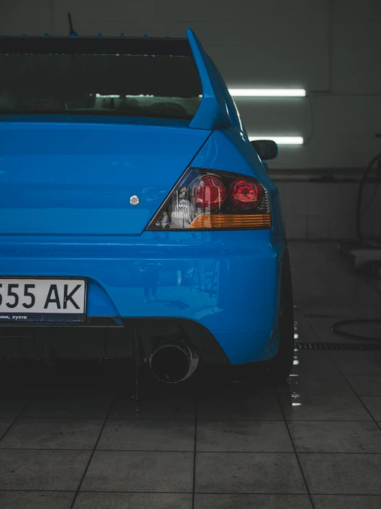 the rear end of a bright blue compact car