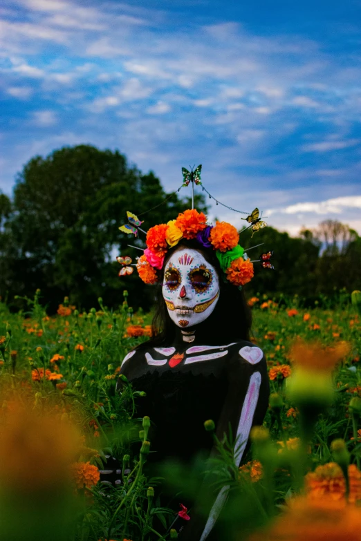 a skeleton woman in flowers is posed in a field