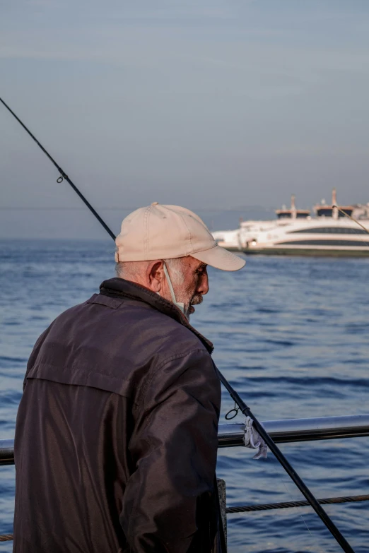 a man standing on a pier fishing from the water