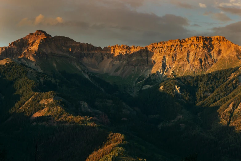 the mountains are glowing at sunset in the distance