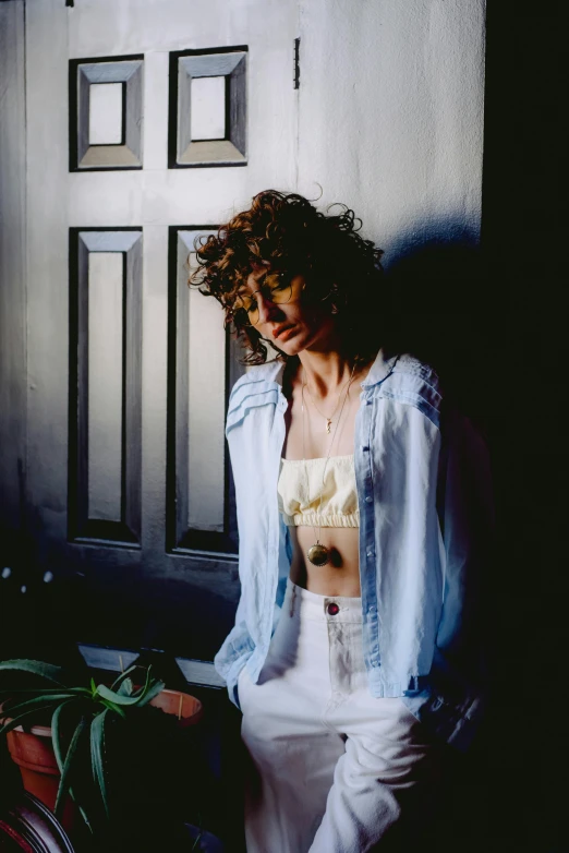 a woman wearing a white top, sitting down