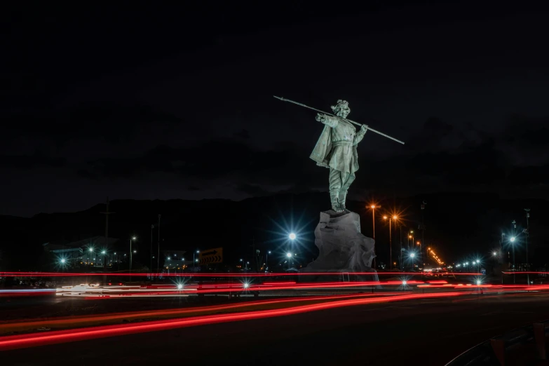 a po taken at night of a man on top of a statue