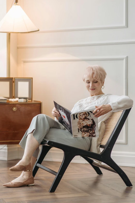 a woman sits in a chair reading a book