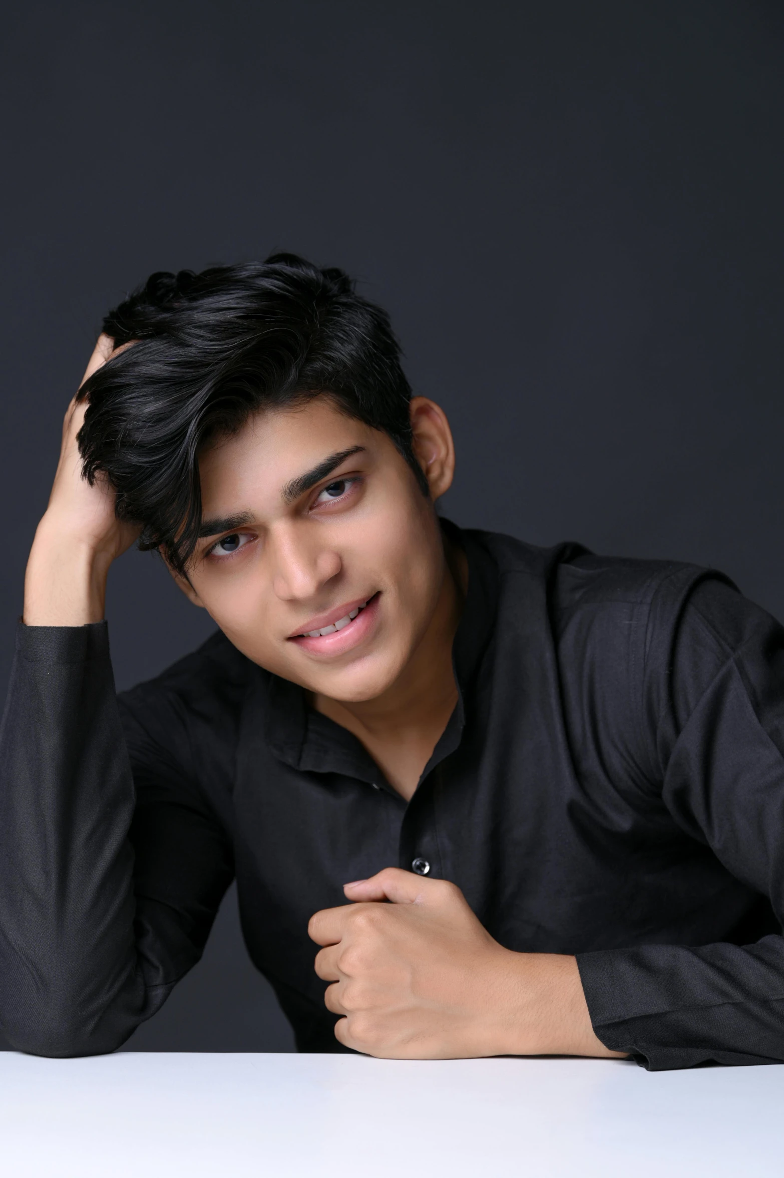 a young man posing for a po holding his hair