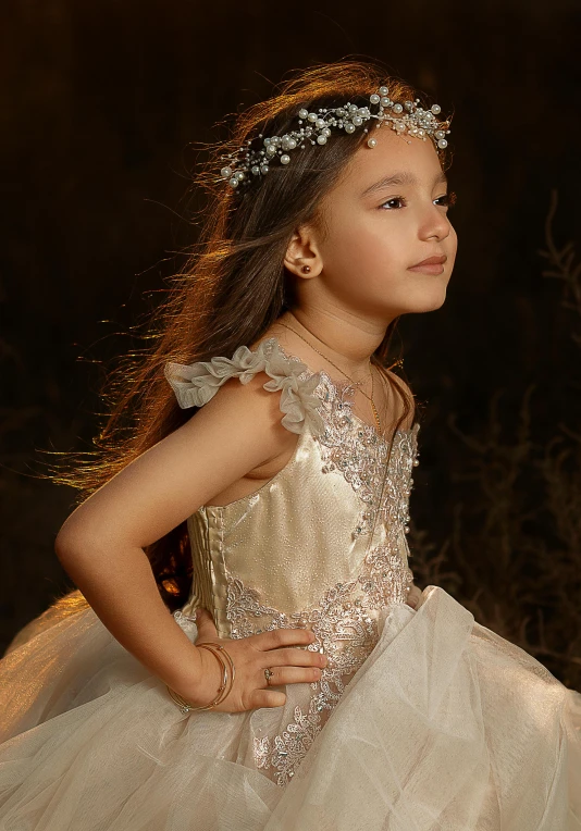 a little girl is dressed up in her wedding gown