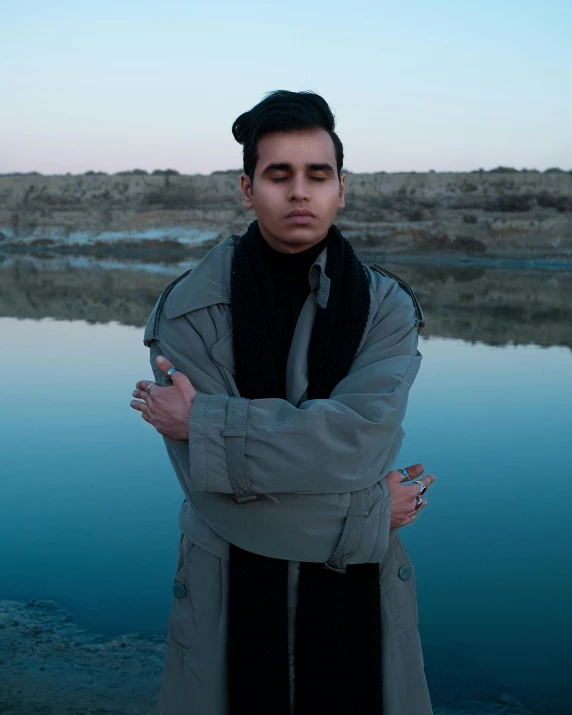 a man standing with his arms crossed in front of the camera