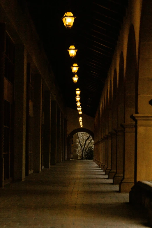 a sidewalk with a row of lights on the ceiling