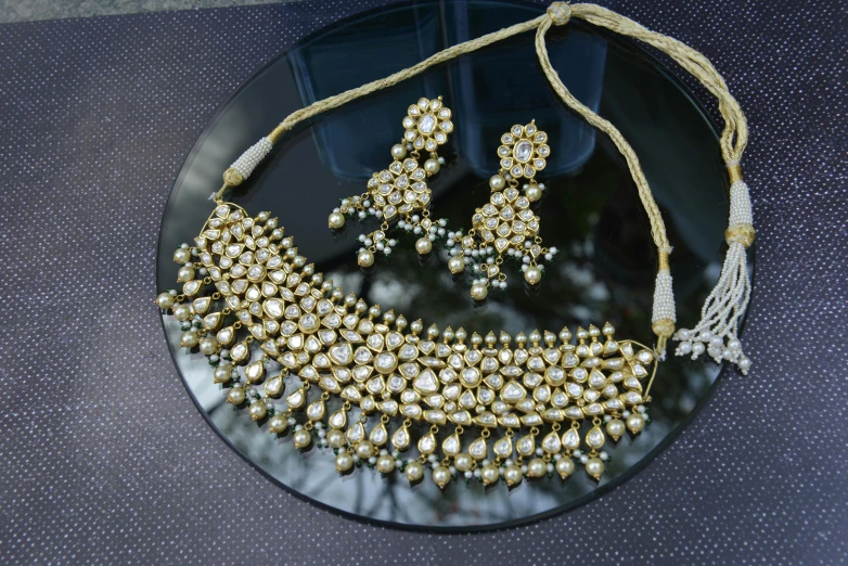 an elegant necklace and earrings sitting on top of a plate