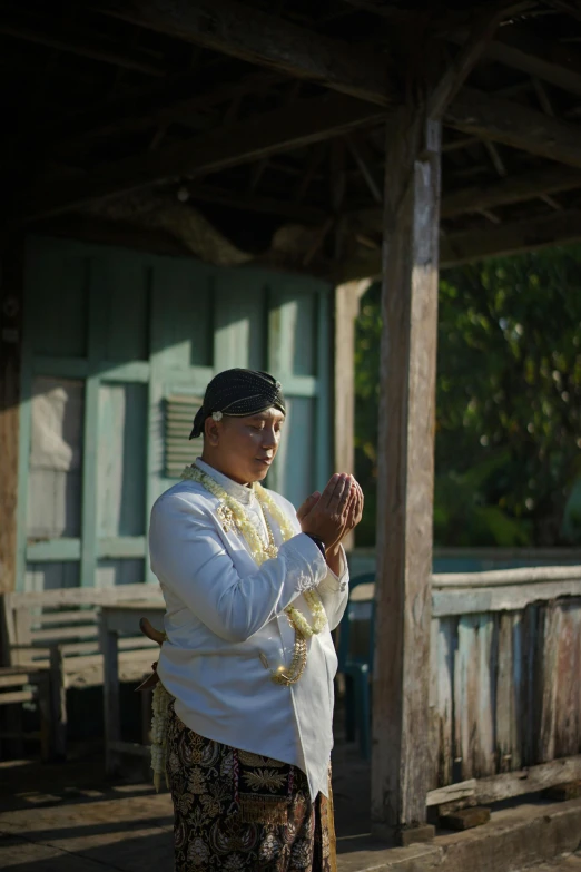 a woman is praying outside her house