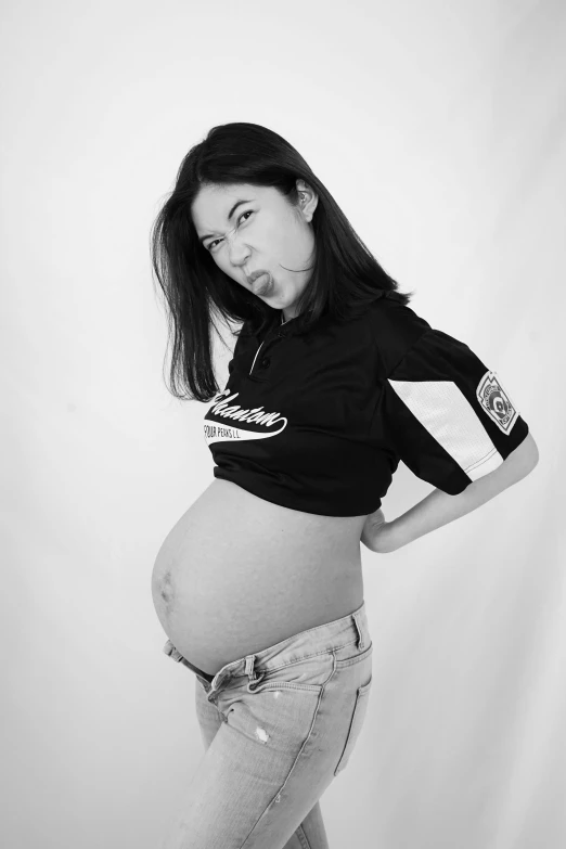 a pregnant woman in her mom's jeans posing for a po