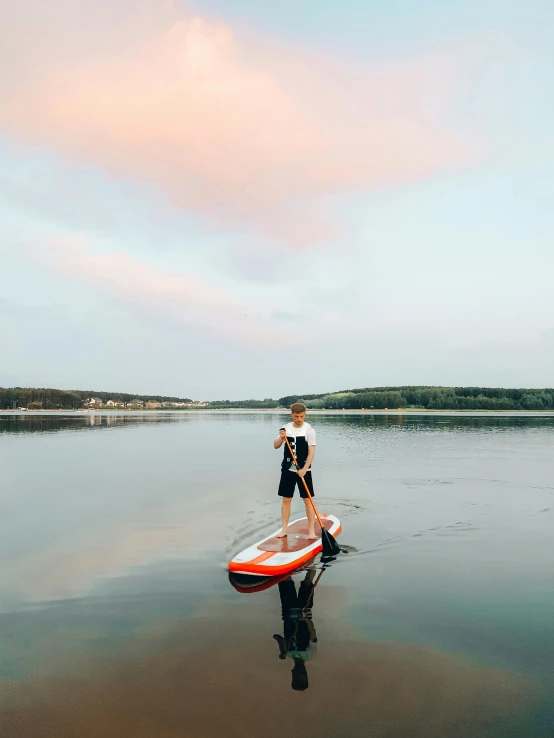 a man stands in the water with a surfboard