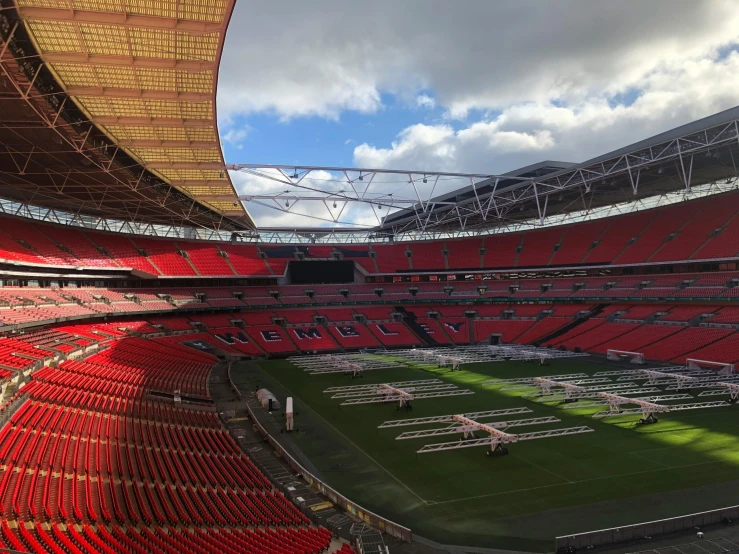 there is a stadium with red seats and a green field