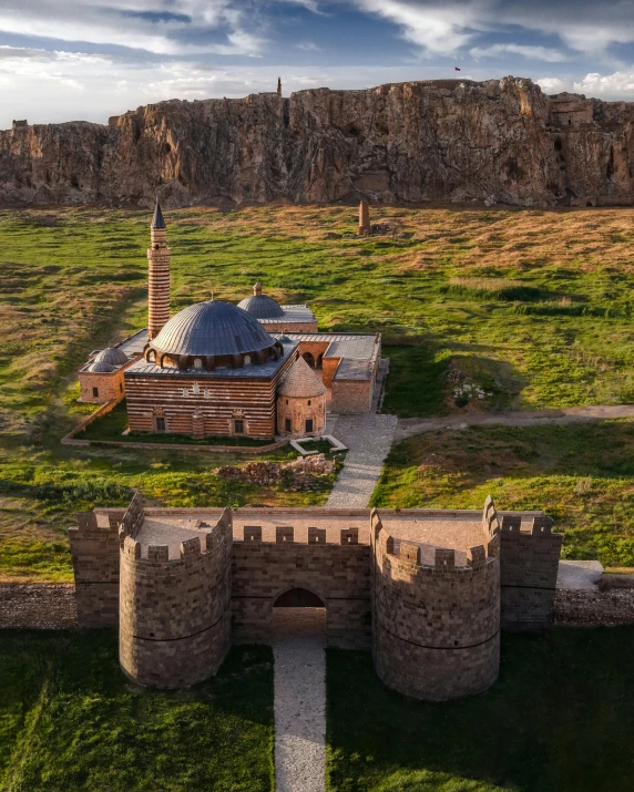 a castle is shown with green grass and tall buildings