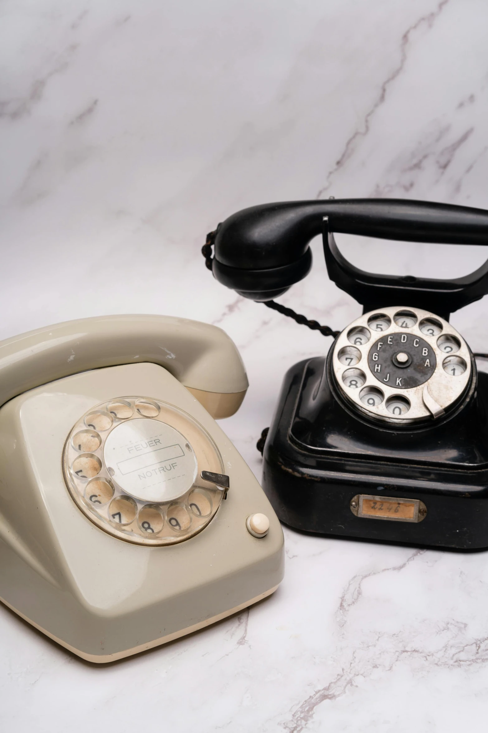 a small old style rotary phone with an older model telephone