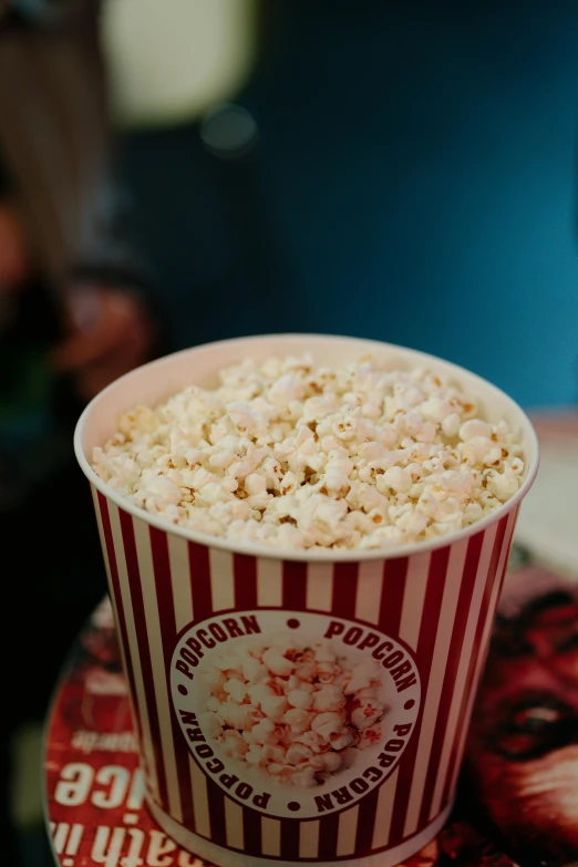 a cup filled with popcorn on top of a table