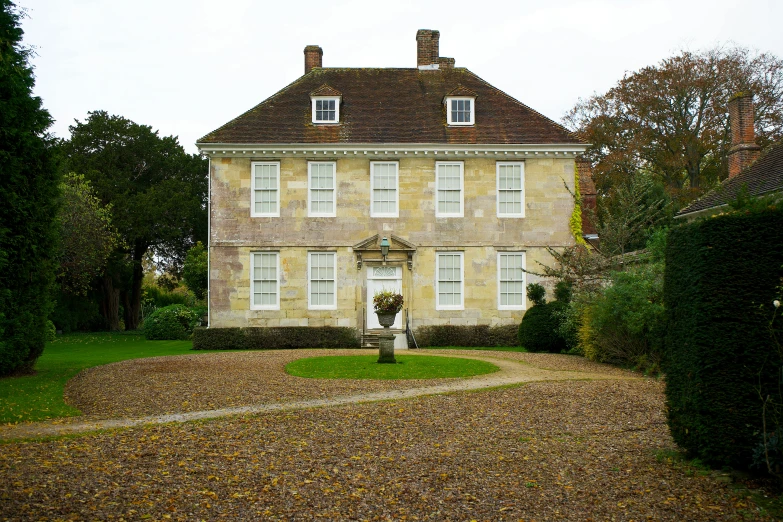 a two story brick house with a front yard and yard in the background