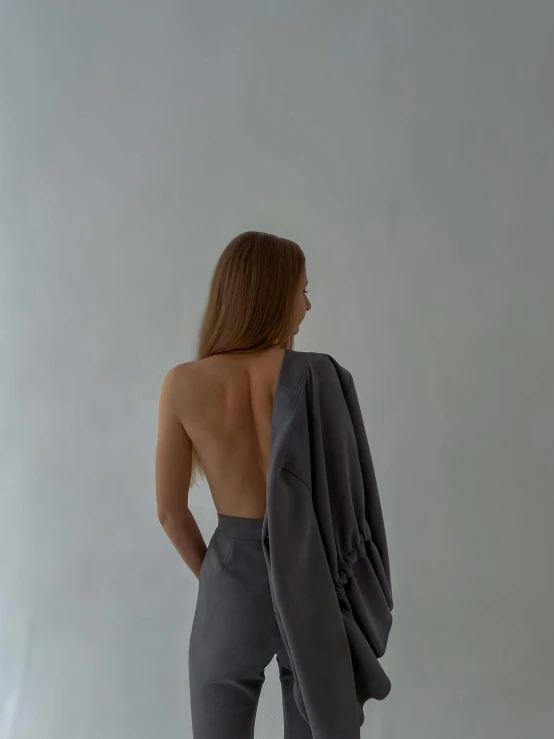 a woman with her back turned, posing for the camera