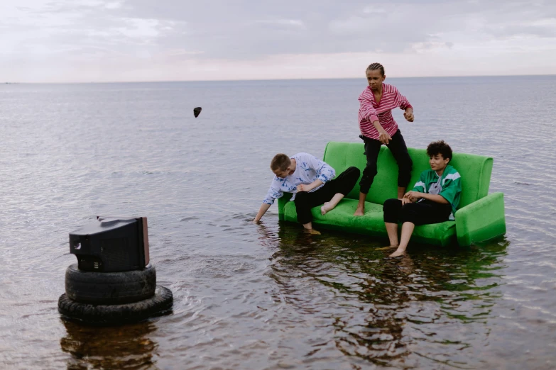 three boys sitting on an inflatable floating chair in the ocean