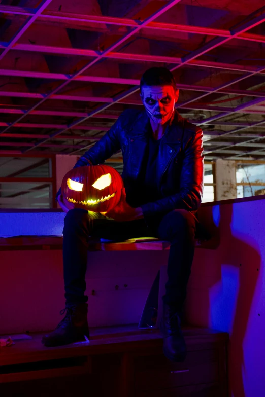 a man sitting down with a glowing pumpkin