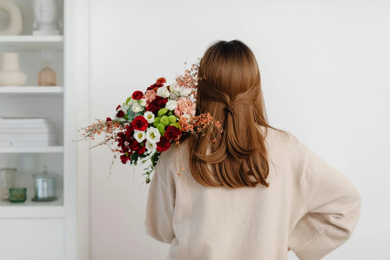 a woman holding a bouquet of flowers by her back