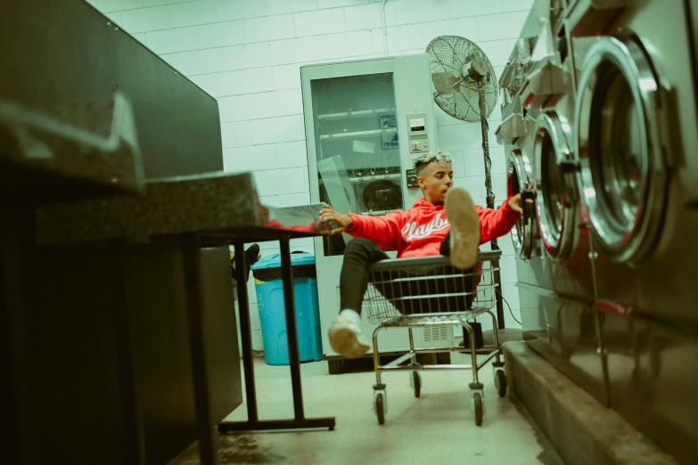 a man is sitting in a shopping cart while someone stands behind him