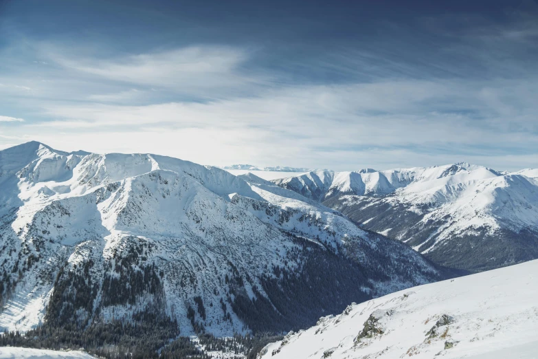 there are snow covered mountains and one mountain is also a small lake