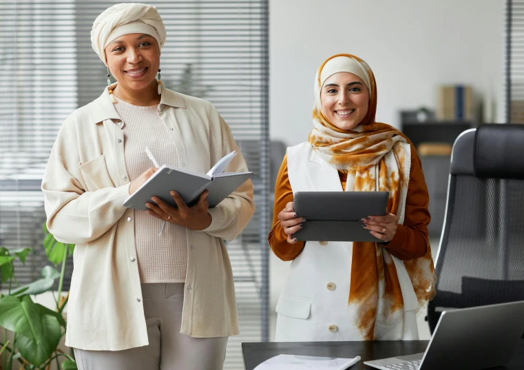 two women standing beside each other holding soing