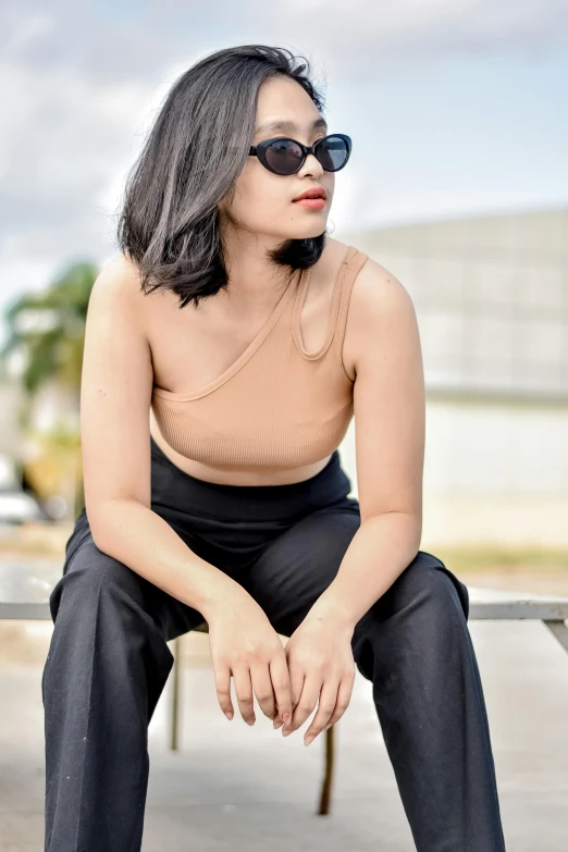 a woman in black is posing on a bench