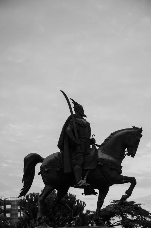 a statue of an person on a horse in front of a cloudy sky