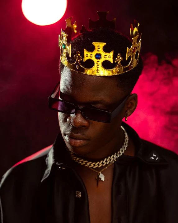 a man wearing sunglasses and a gold crown on his head