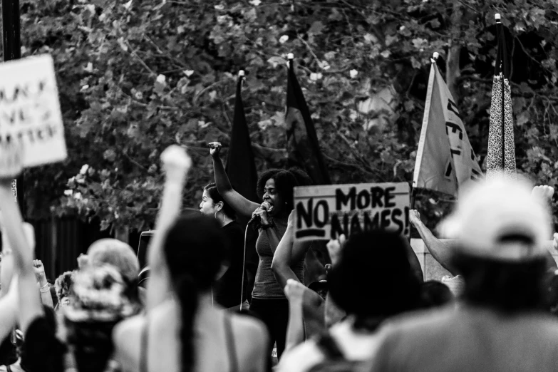 black and white image of people walking holding protest signs