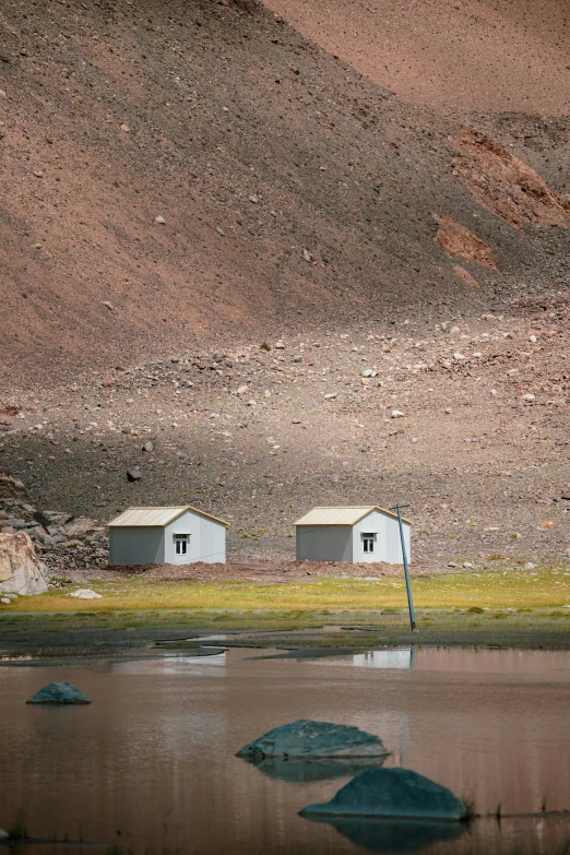 the back of a mountain with several shacks in it