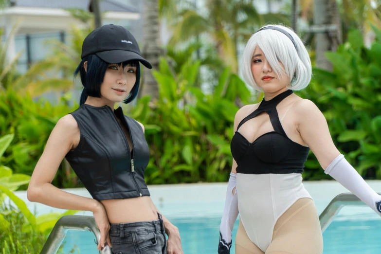 two women are posing in costume by the pool