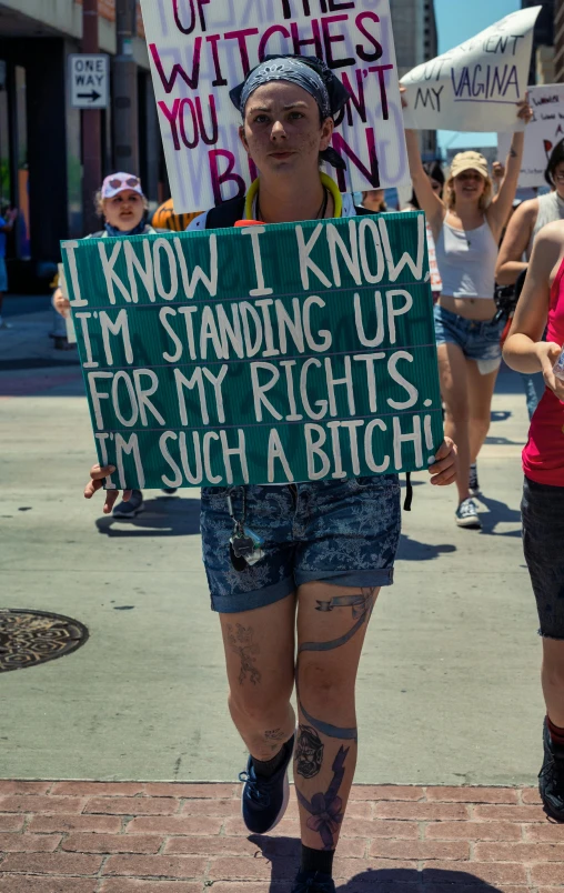 a man in shorts holding a protest sign