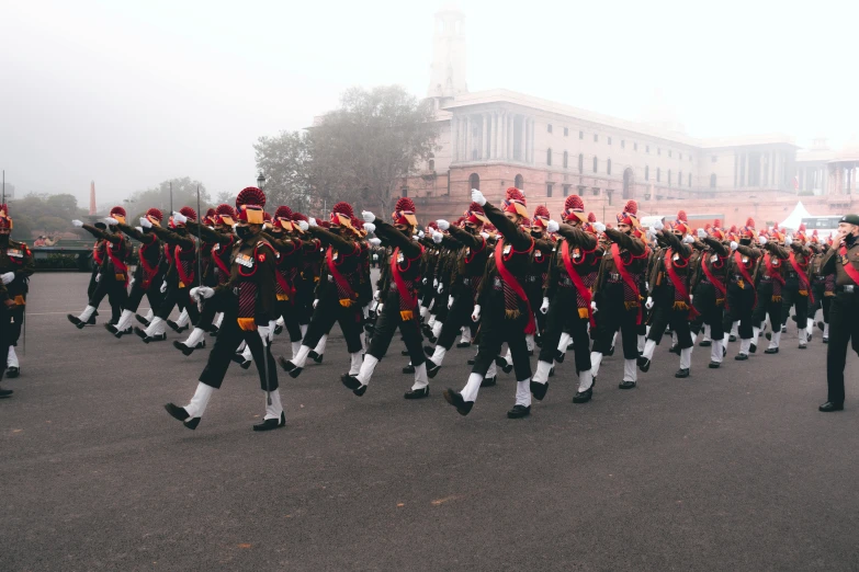 many uniformed men in uniform marching in the street