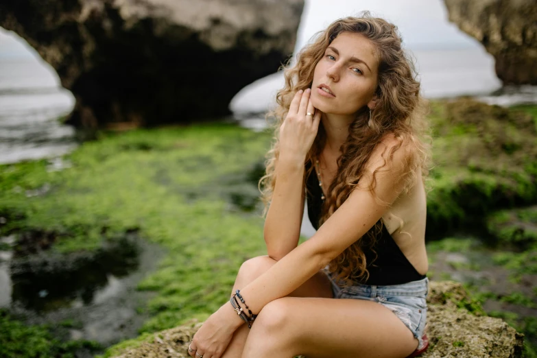 the woman is posing for the camera by a water