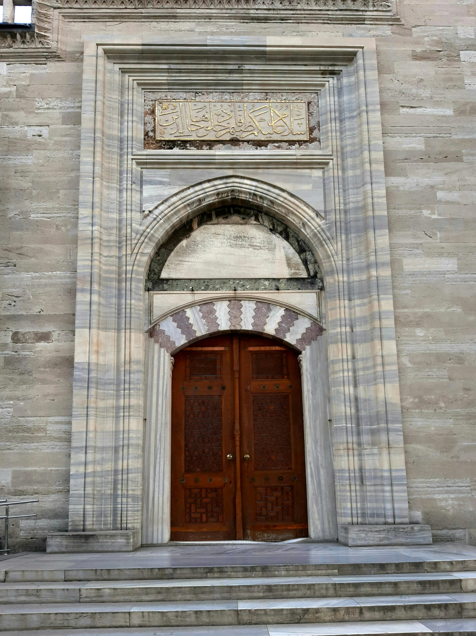 a building with two brown doors and a staircase