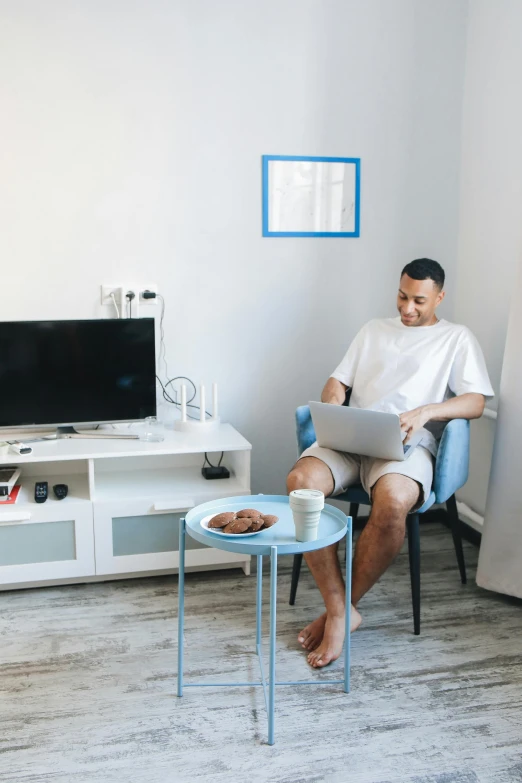 man in white shirt using laptop computer at sitting area