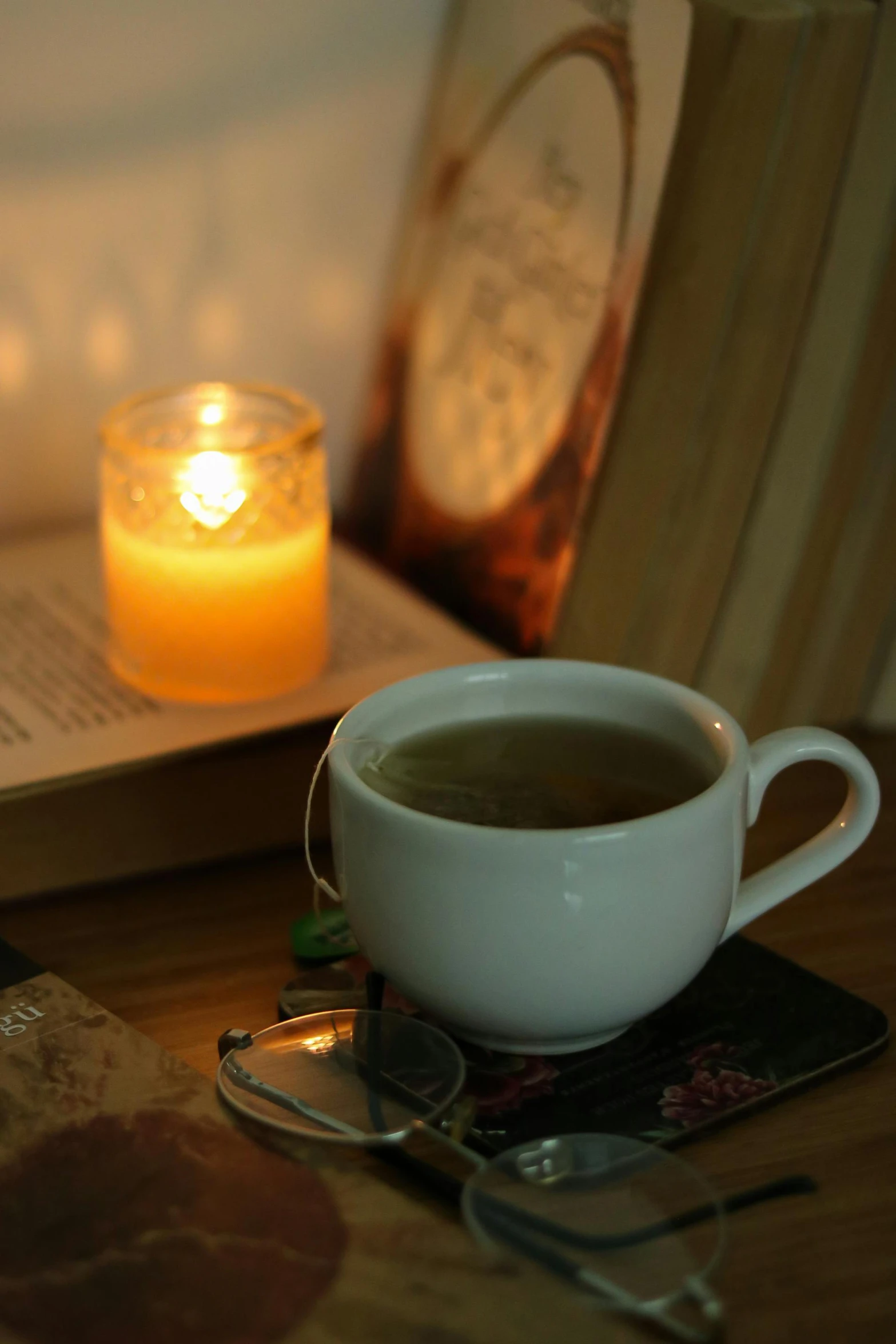 an open book and coffee cup on top of a table