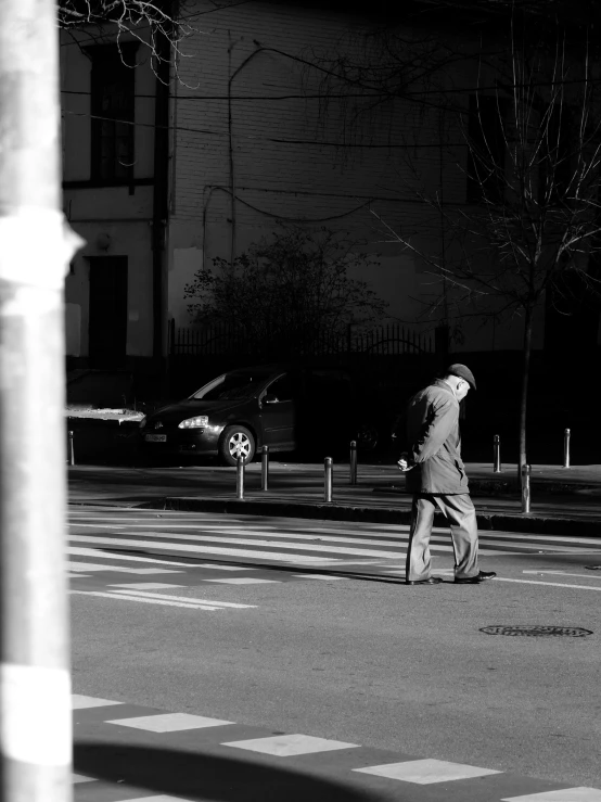 a black and white po of an older man crossing the street