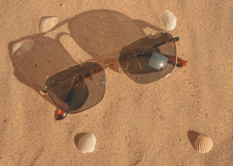 a pair of sunglasses on the sand at the beach