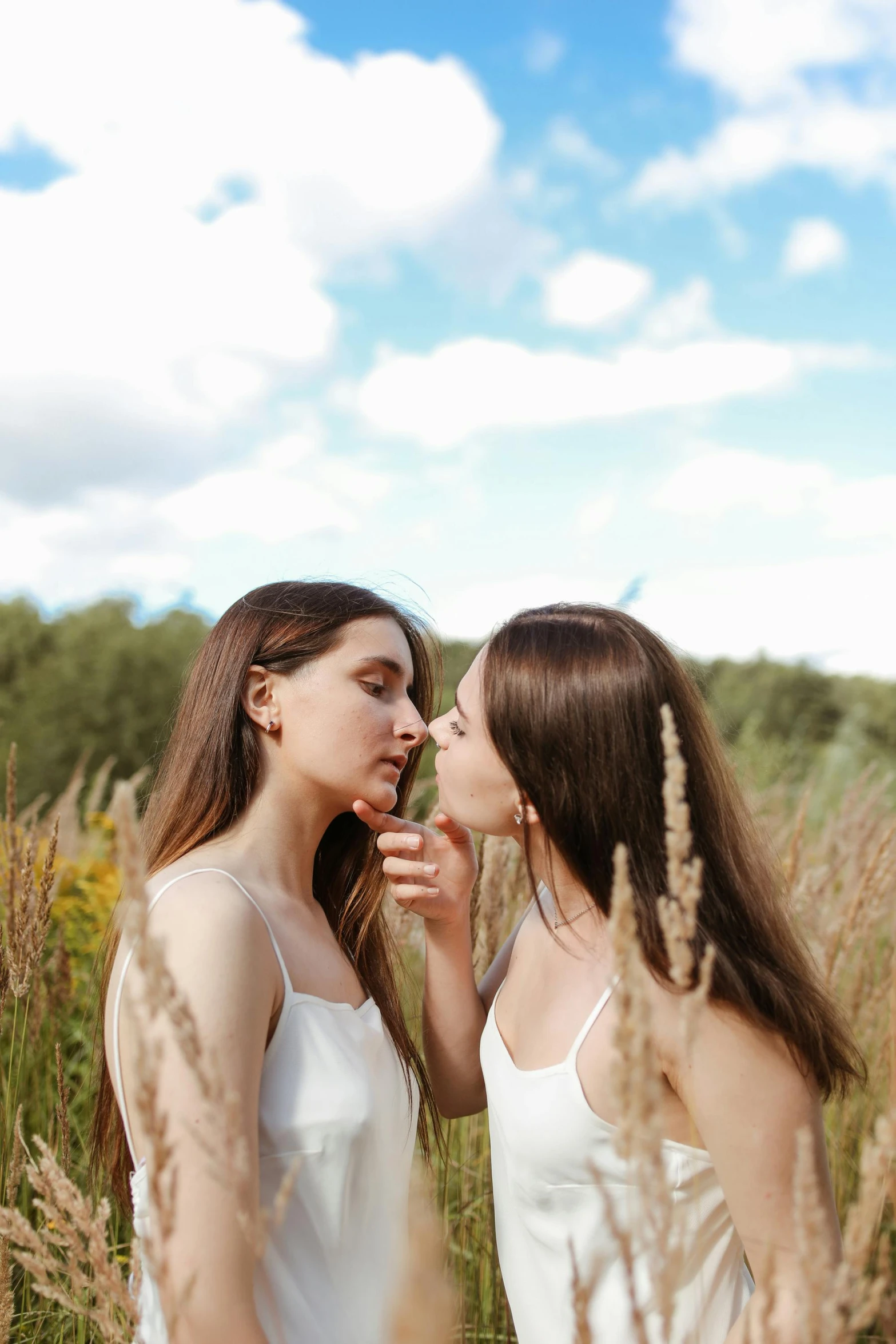 two girls face to face in tall grasses