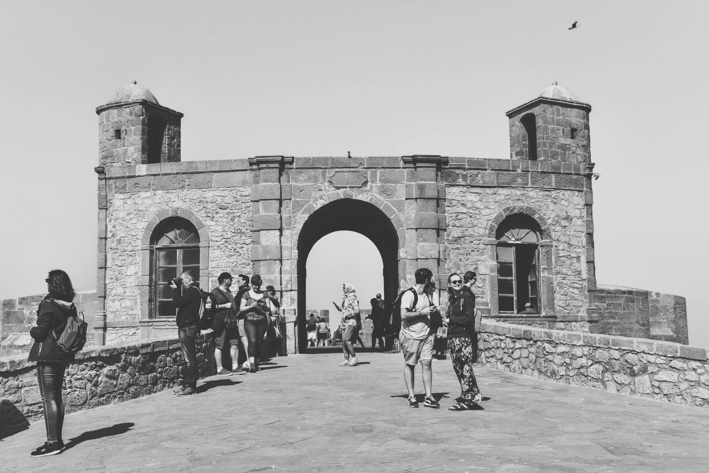 two women walking to a castle with a man on horseback behind her