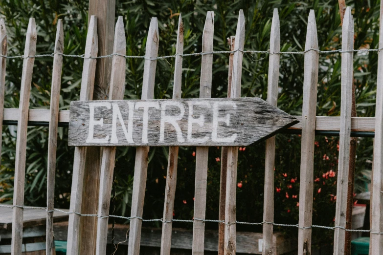 a fence with a wooden sign hanging from it