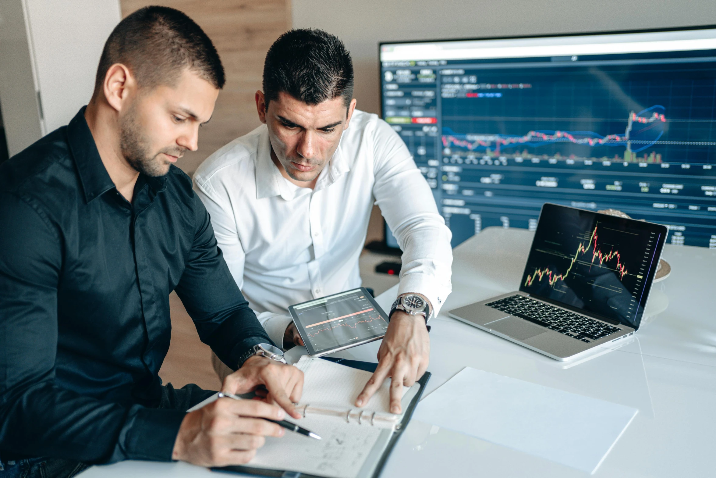 two men with an open laptop look at soing