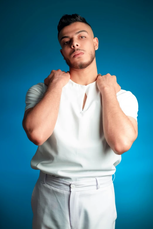 a man wearing a white polo shirt and a pair of gloves