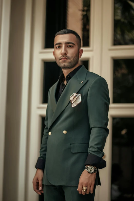 a man in a green suit standing outside of a window